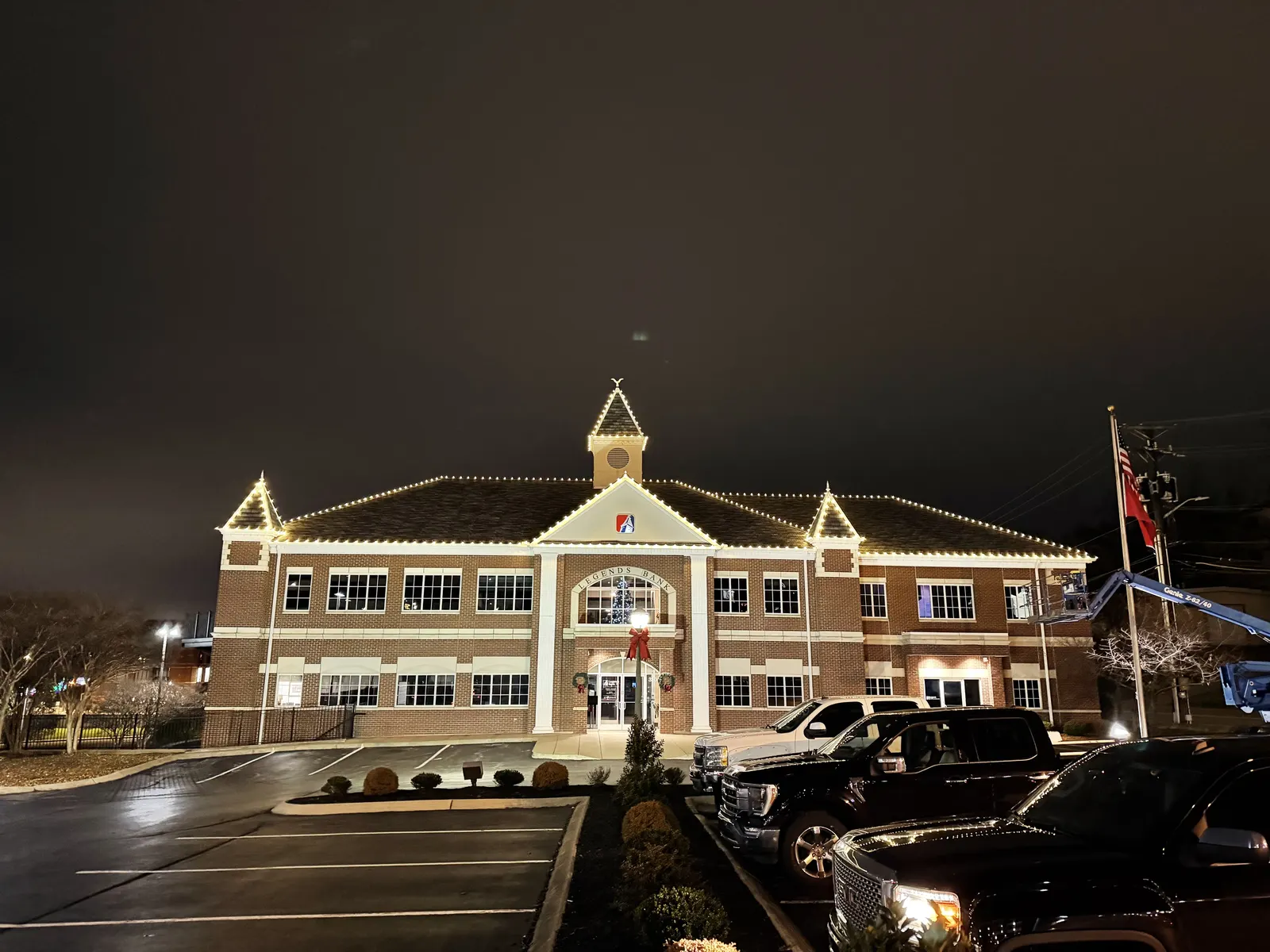 White holiday lights along the roofline of a commercial building