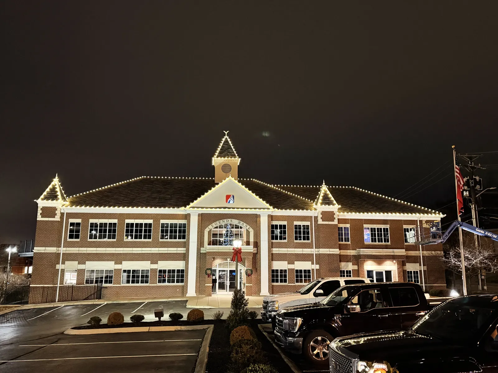 Warm white holiday lights outlining the roof of a commercial building